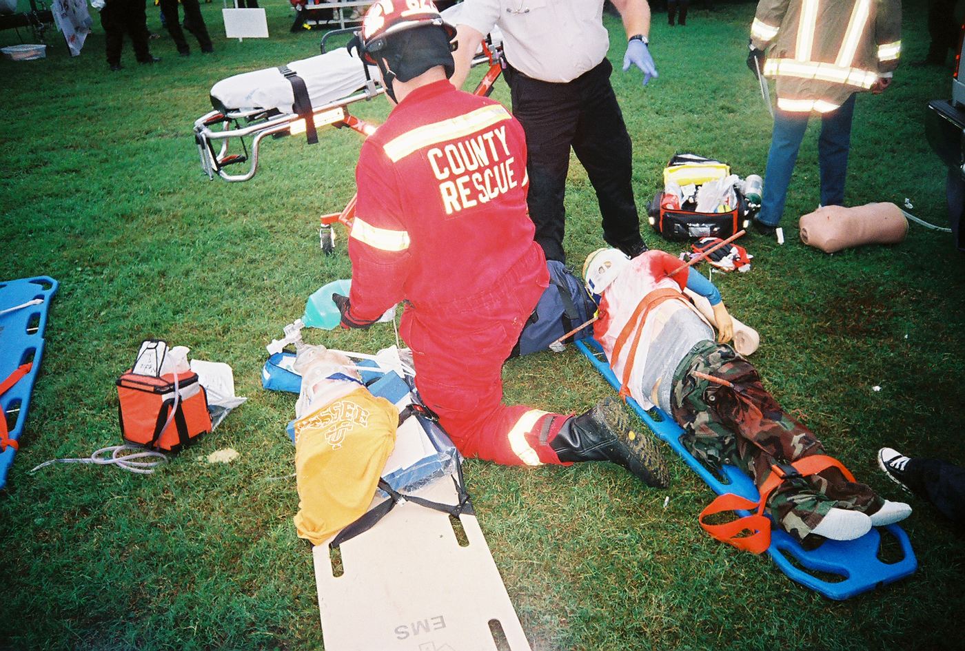 A rescuer in red working a patient on a blue backboard in Charleston, 2008