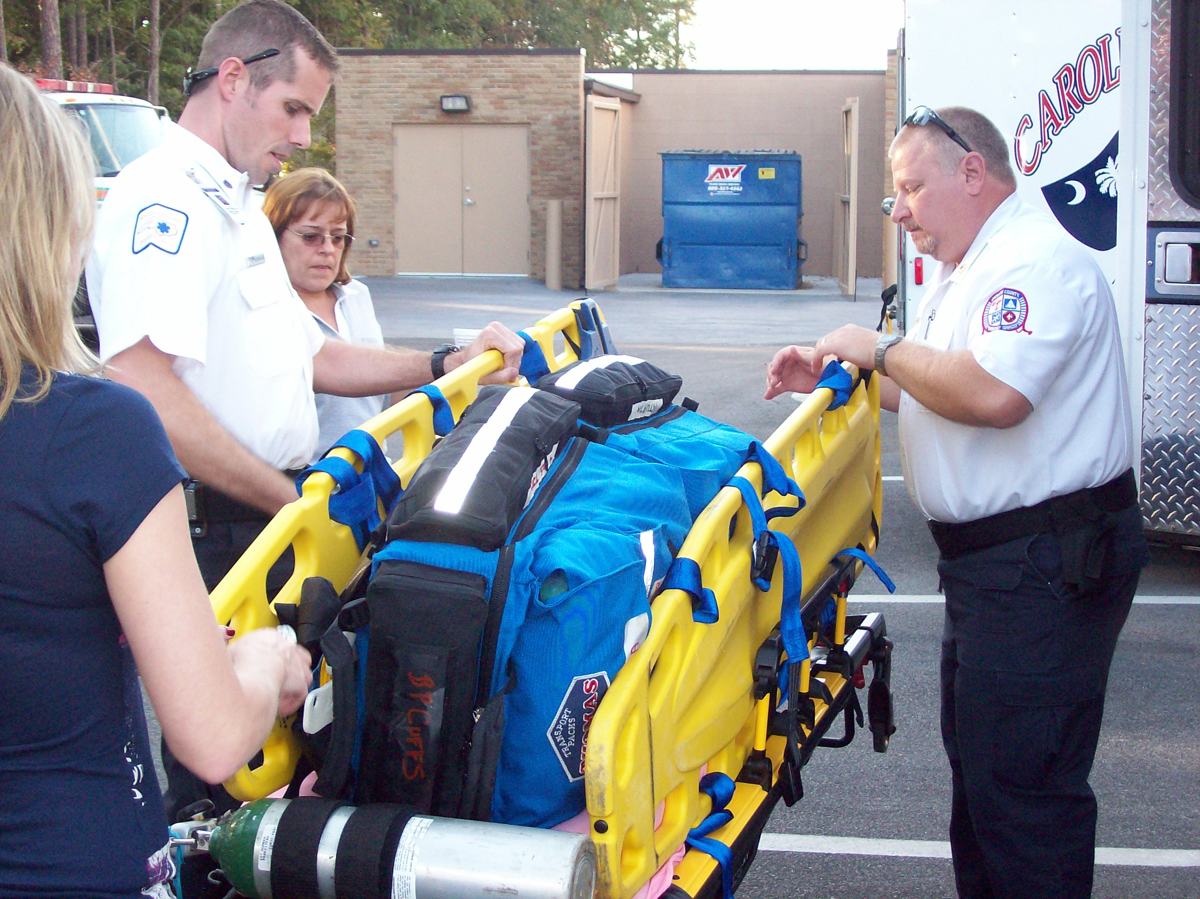 A crew loading a stretcher beside their ambulance in Florence