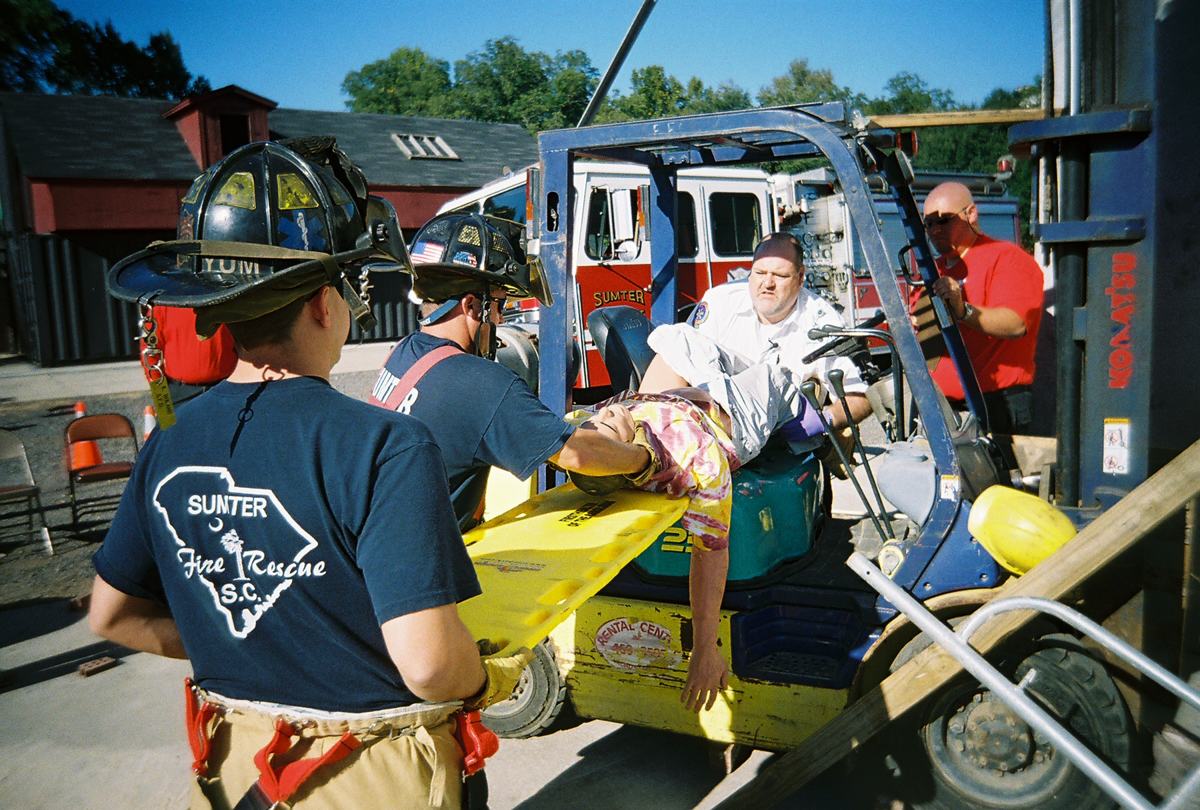 A team moving a patient from a forklift onto a backboard in Sumter